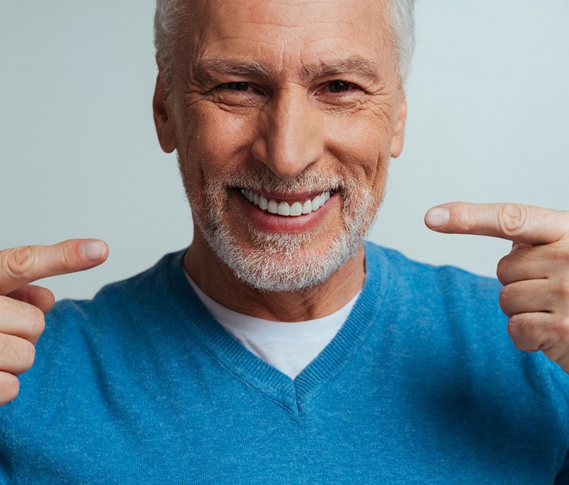 Happy senior man pointing at his smile