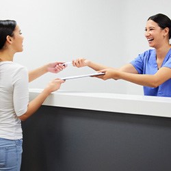 Patient in Hingham talking to staff about payment options for dental crowns