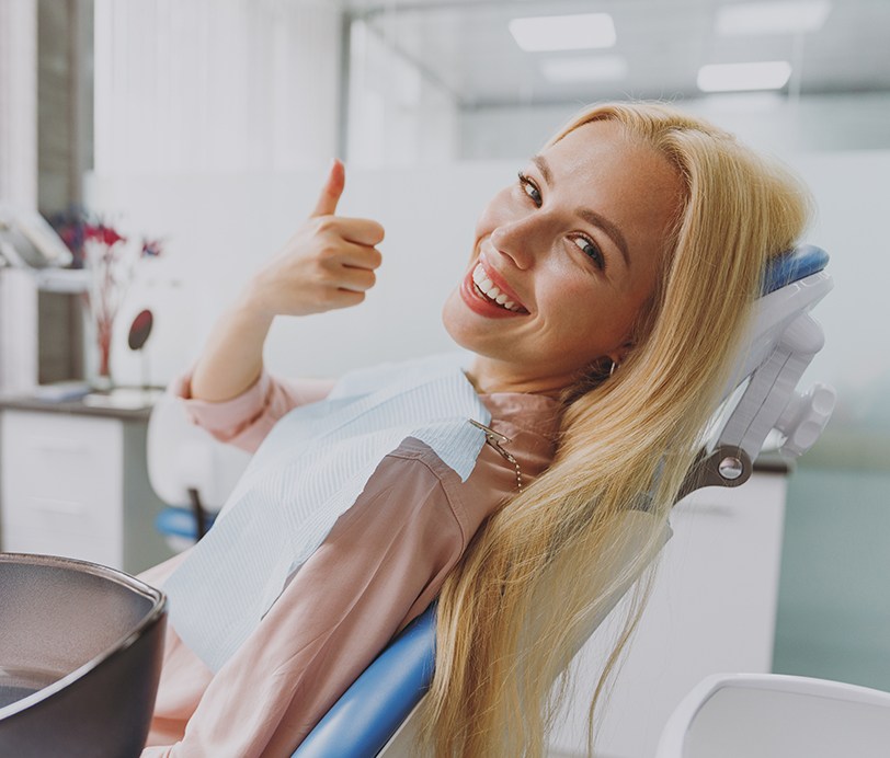 Blonde female dental patient giving thumbs up